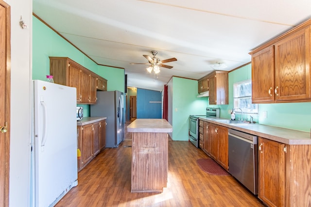 kitchen featuring stainless steel appliances, a kitchen island, a sink, and light countertops