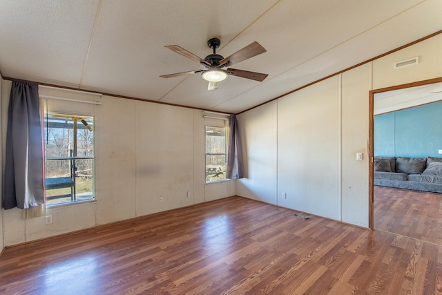 spare room featuring ceiling fan, visible vents, crown molding, and wood finished floors