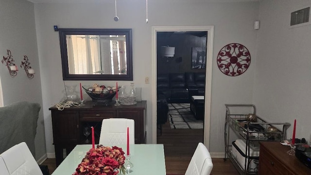 dining room with baseboards, visible vents, and wood finished floors