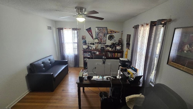 office area with visible vents, ceiling fan, a textured ceiling, wood finished floors, and baseboards