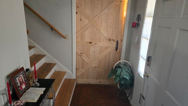 doorway to outside featuring stairway, baseboards, and a barn door