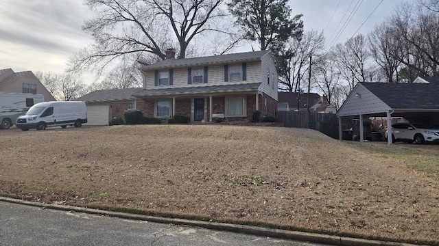 traditional-style home featuring a garage, brick siding, and fence