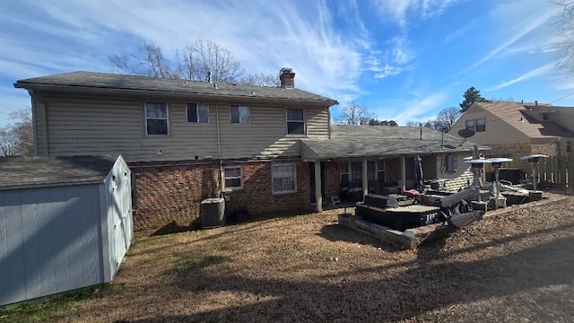 rear view of house featuring brick siding, a yard, a chimney, central air condition unit, and fence