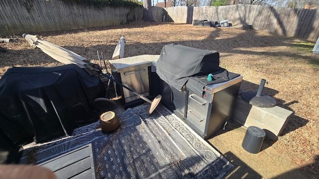 wooden deck with a fenced backyard and an outdoor kitchen