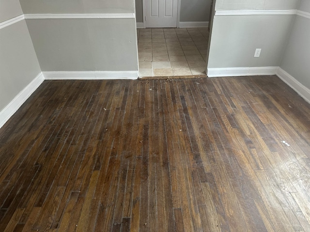 spare room with hardwood / wood-style flooring and baseboards