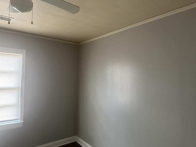 unfurnished room with baseboards, visible vents, ceiling fan, and crown molding