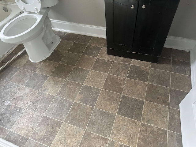 bathroom featuring tile patterned flooring, toilet, and baseboards