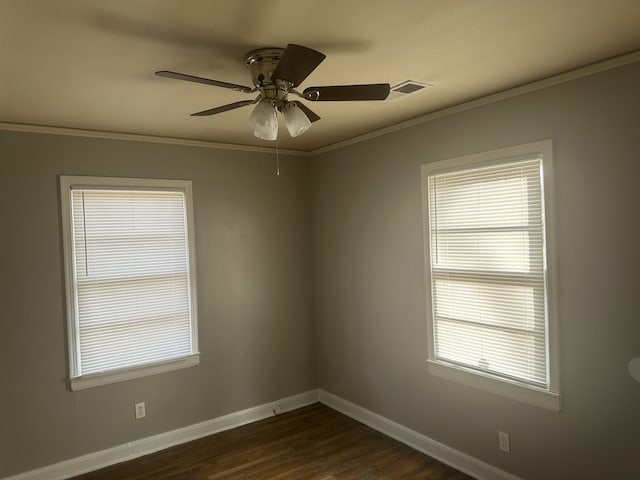 spare room with visible vents, baseboards, dark wood-style floors, ceiling fan, and crown molding