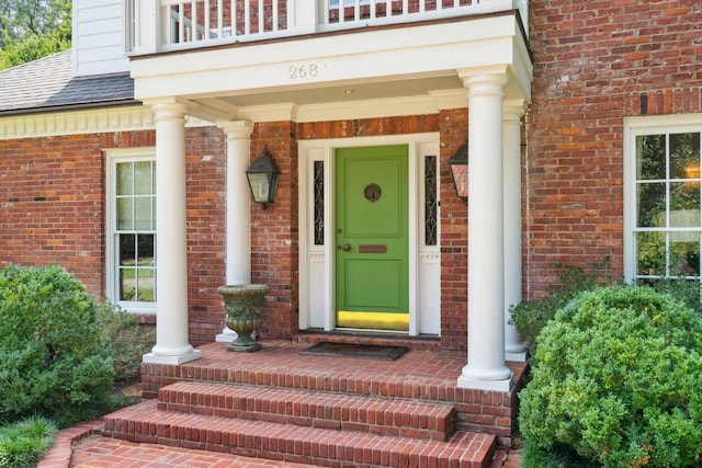 property entrance with brick siding and roof with shingles