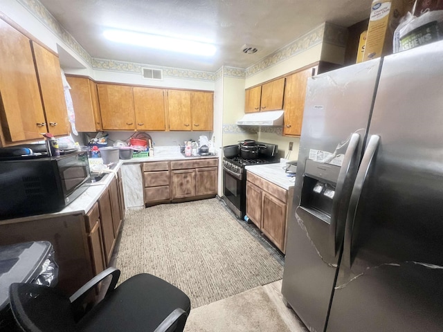 kitchen featuring stainless steel appliances, brown cabinets, light countertops, and under cabinet range hood