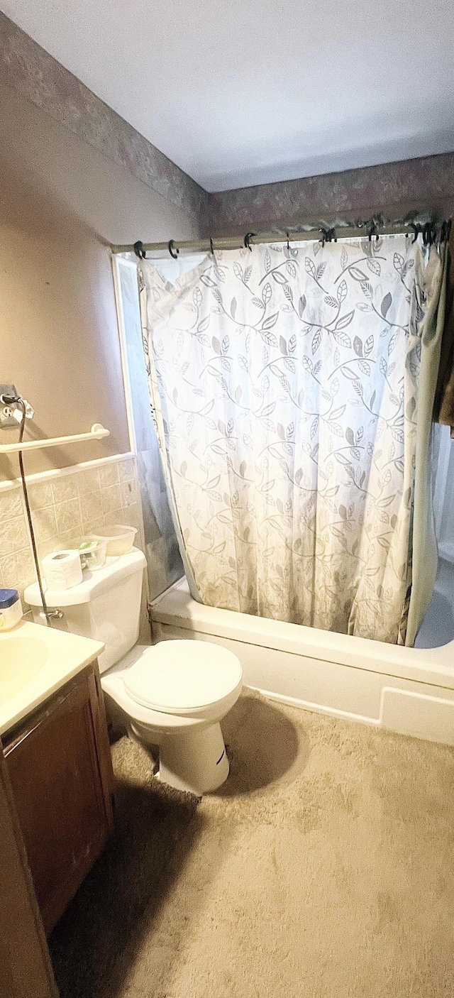 full bathroom with shower / tub combo with curtain, tile walls, toilet, and vanity