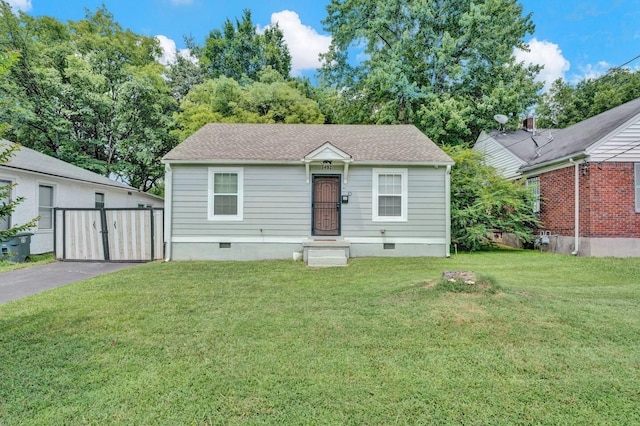 view of front of property featuring crawl space, driveway, a front lawn, and roof with shingles