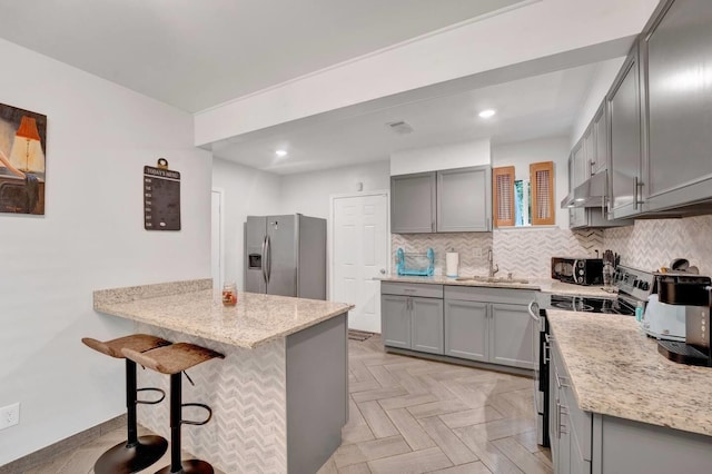 kitchen featuring stainless steel appliances, gray cabinets, and a sink