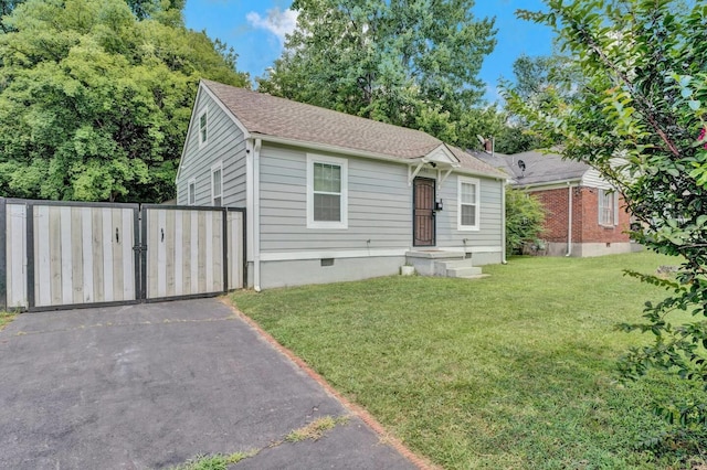 view of front of home featuring fence, roof with shingles, crawl space, a gate, and a front yard