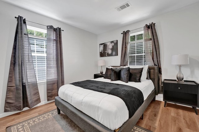 bedroom with visible vents and wood finished floors