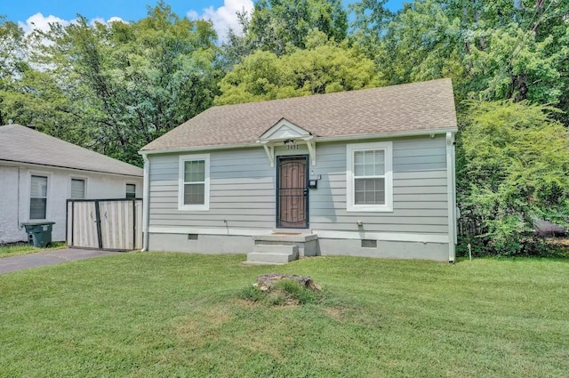 view of front of home featuring a shingled roof, a front yard, crawl space, and driveway