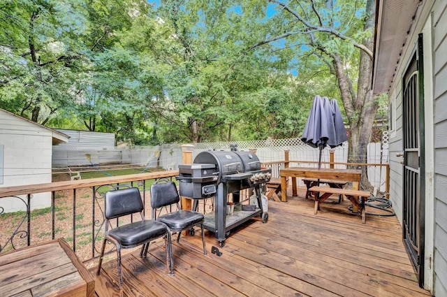 deck with area for grilling and a fenced backyard