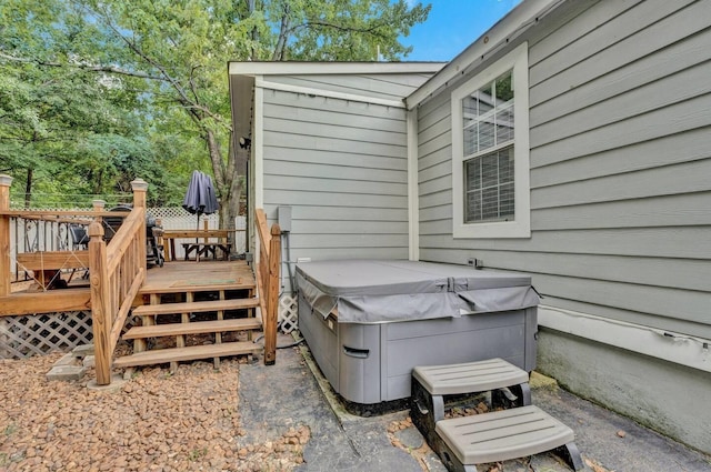 exterior space with a hot tub and a wooden deck