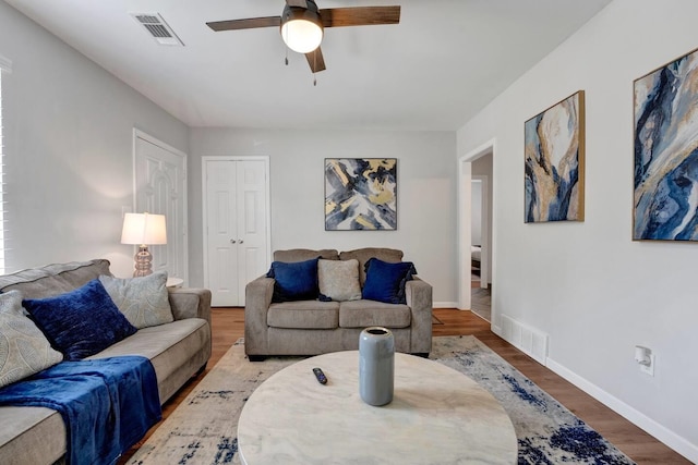 living area featuring wood finished floors, visible vents, and baseboards