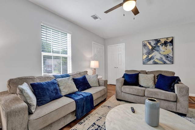 living area featuring visible vents, ceiling fan, and wood finished floors