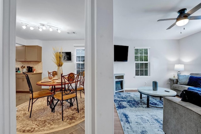 living room featuring ceiling fan, light wood finished floors, and visible vents