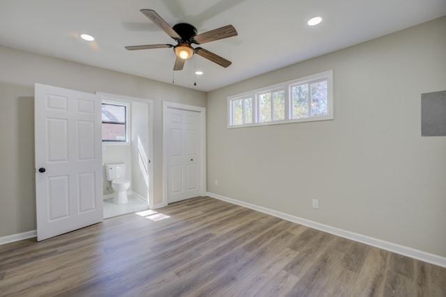 unfurnished bedroom with recessed lighting, wood finished floors, and baseboards