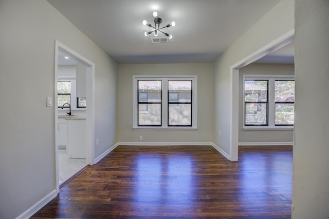 interior space featuring a sink, visible vents, baseboards, dark wood finished floors, and an inviting chandelier