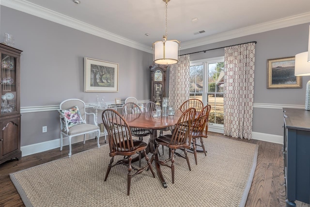 dining area featuring ornamental molding, wood finished floors, visible vents, and baseboards