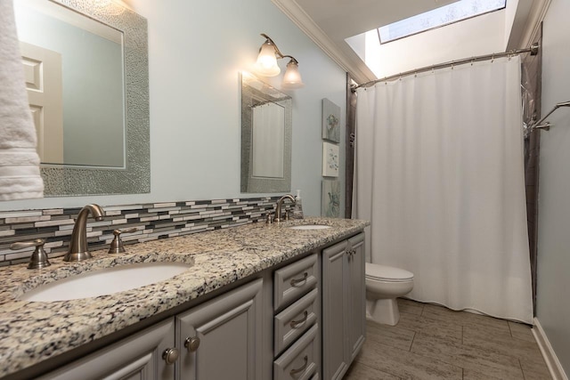 full bath with toilet, a skylight, decorative backsplash, and a sink