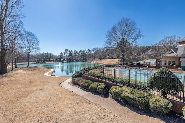 view of pool featuring a water view and fence