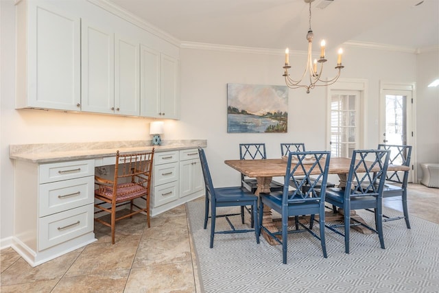 dining area featuring an inviting chandelier, baseboards, built in desk, and crown molding