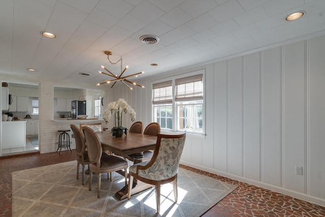 dining space featuring recessed lighting, an inviting chandelier, visible vents, and a decorative wall