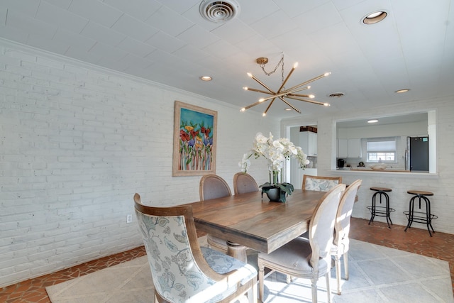 dining room featuring brick wall, visible vents, and recessed lighting