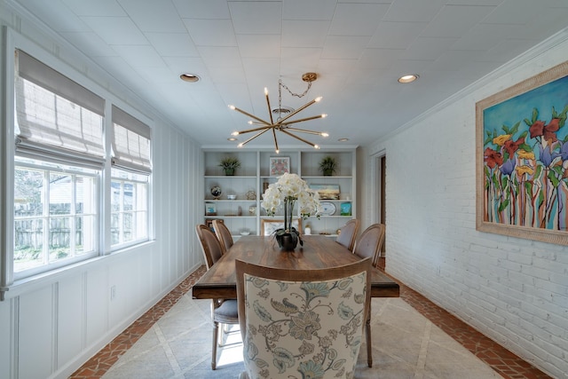 dining area with recessed lighting, brick wall, built in features, an inviting chandelier, and crown molding