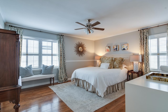 bedroom with multiple windows, dark wood finished floors, and crown molding