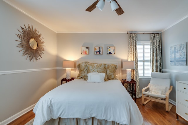 bedroom featuring baseboards, ornamental molding, ceiling fan, and wood finished floors