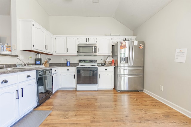 kitchen with lofted ceiling, white cabinetry, light wood-style floors, appliances with stainless steel finishes, and dark countertops