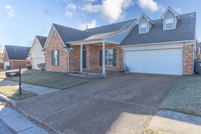 view of front of property featuring brick siding, a shingled roof, concrete driveway, an attached garage, and a front yard