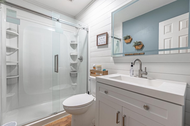 full bathroom with toilet, wooden walls, a shower stall, wood finished floors, and vanity