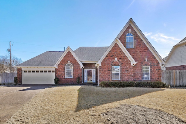 view of front of house with concrete driveway, brick siding, fence, and a front lawn