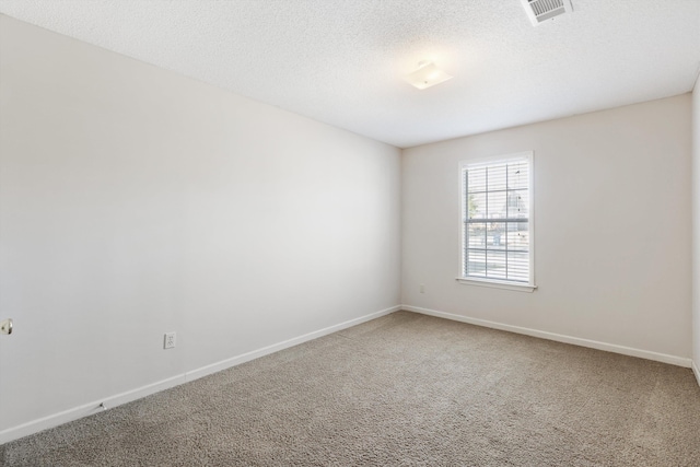 carpeted empty room featuring baseboards, visible vents, and a textured ceiling