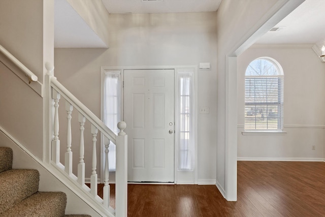 entrance foyer featuring visible vents, stairs, baseboards, and wood finished floors