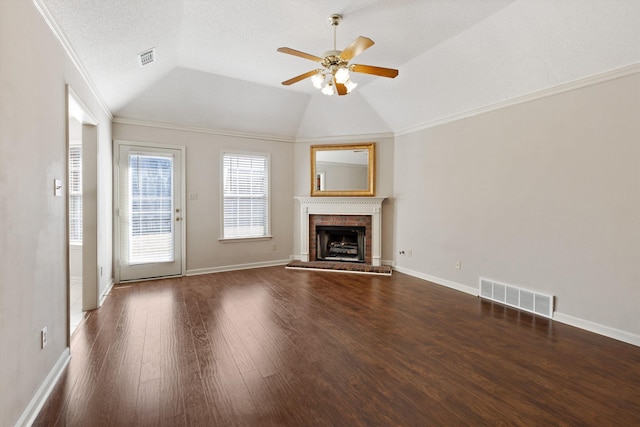 unfurnished living room featuring visible vents, lofted ceiling, dark wood-style floors, ceiling fan, and a brick fireplace