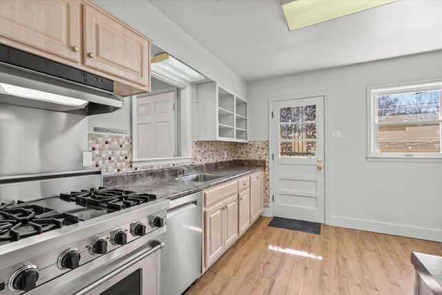 kitchen with under cabinet range hood, appliances with stainless steel finishes, backsplash, and a sink