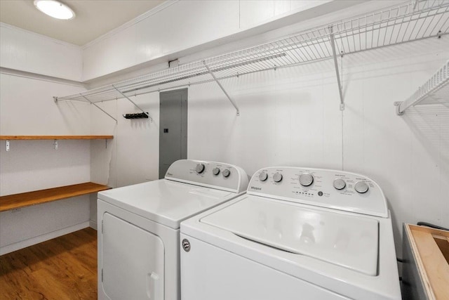 washroom featuring laundry area, washing machine and dryer, electric panel, and wood finished floors