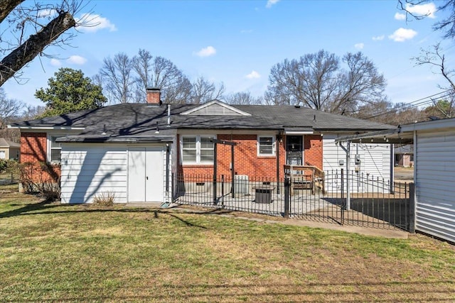 rear view of house with brick siding, fence, a lawn, a chimney, and a patio area