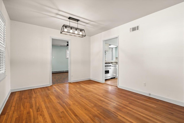 unfurnished dining area featuring a baseboard radiator, baseboards, visible vents, and wood finished floors