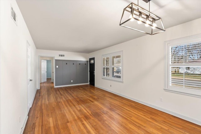 interior space featuring wood finished floors, visible vents, and baseboards