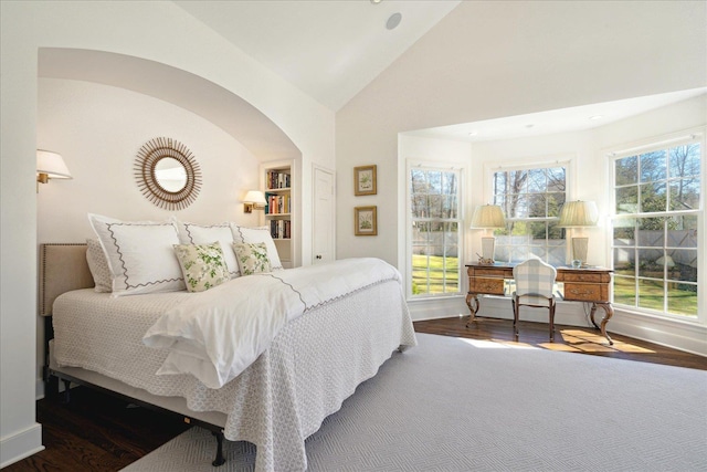 bedroom featuring multiple windows, baseboards, and wood finished floors