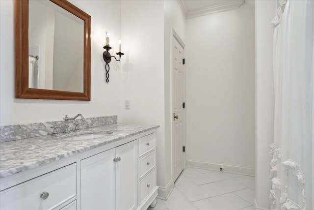 bathroom with ornamental molding, tile patterned flooring, vanity, and baseboards